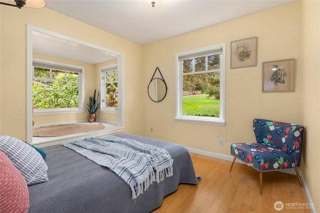 bedroom with hardwood / wood-style floors and baseboards