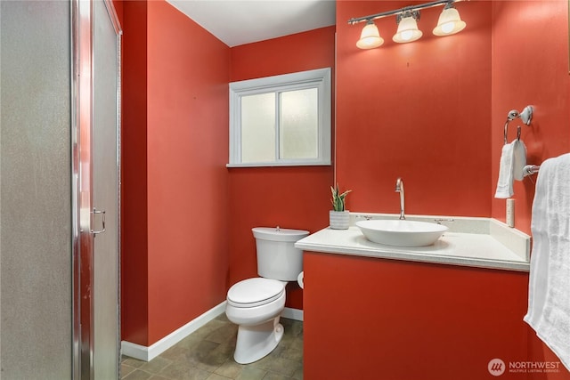 bathroom with baseboards, toilet, and vanity