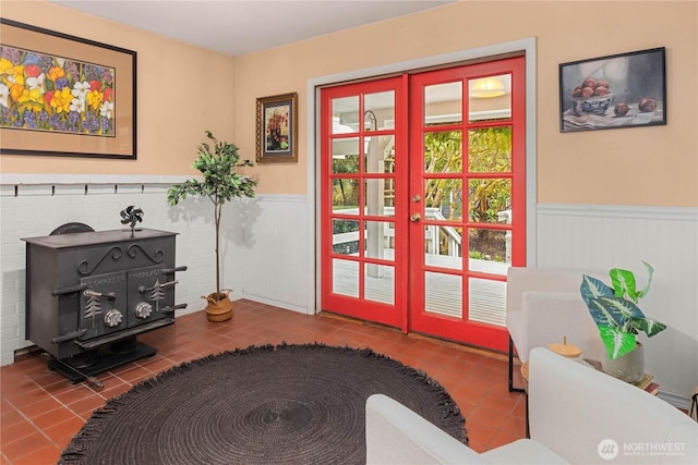 sitting room with tile patterned flooring, french doors, and wainscoting