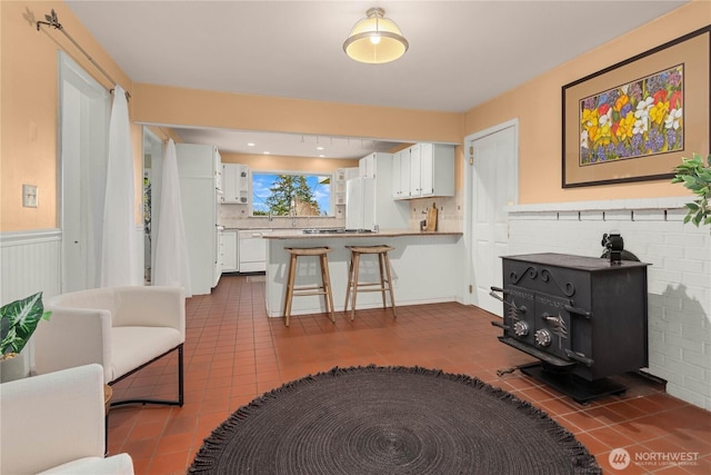 living area with dark tile patterned floors and wainscoting