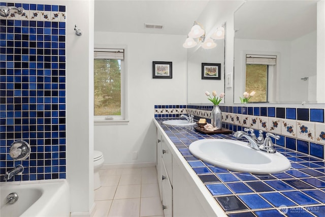 full bathroom with a sink, visible vents, toilet, and tile patterned floors