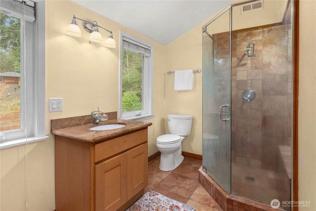 bathroom with visible vents, toilet, lofted ceiling, a stall shower, and vanity