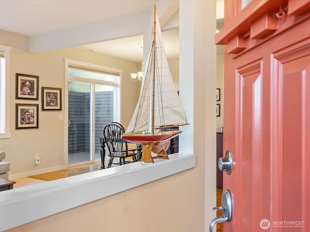 foyer entrance featuring a notable chandelier and baseboards