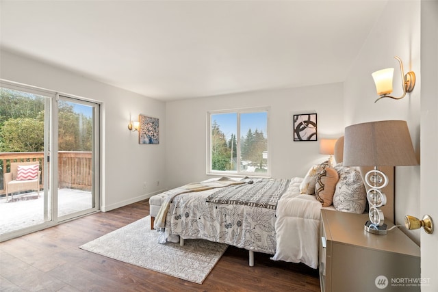 bedroom with hardwood / wood-style floors, multiple windows, and access to outside