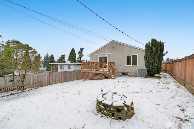 snow covered rear of property featuring a deck and central AC