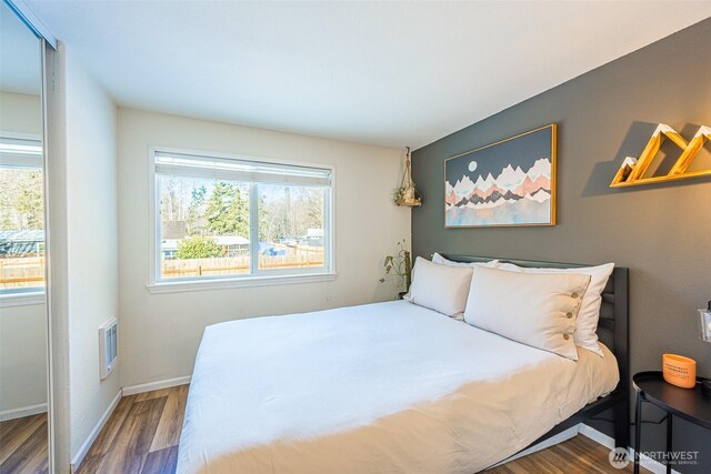 bedroom featuring dark wood-style floors, visible vents, and baseboards