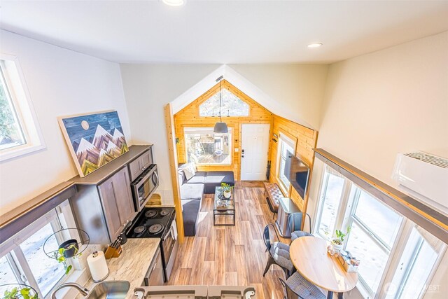 living room featuring vaulted ceiling, light wood finished floors, and recessed lighting