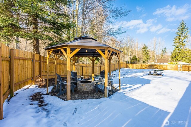 yard covered in snow featuring a gazebo, an outdoor fire pit, and a fenced backyard