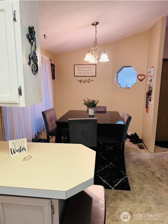 dining room featuring light carpet and a chandelier