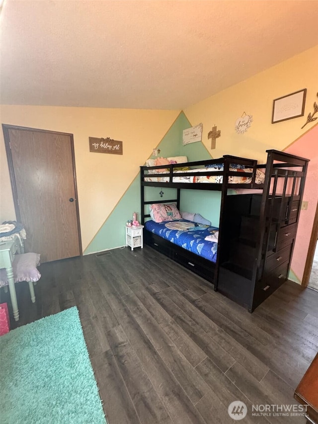 bedroom with dark wood-style flooring