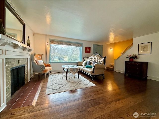 living room with a tile fireplace and dark wood-type flooring