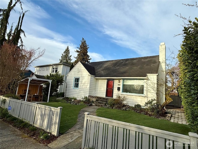 view of front of house with a fenced front yard, a chimney, and a front yard