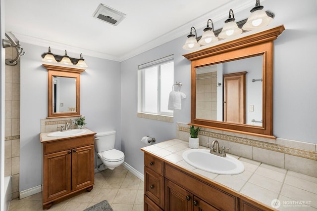 bathroom with toilet, ornamental molding, a sink, and visible vents