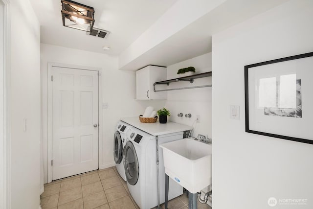 clothes washing area with light tile patterned flooring, a sink, visible vents, independent washer and dryer, and cabinet space