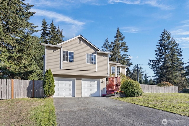 view of front of property with a garage, fence, driveway, and a front lawn