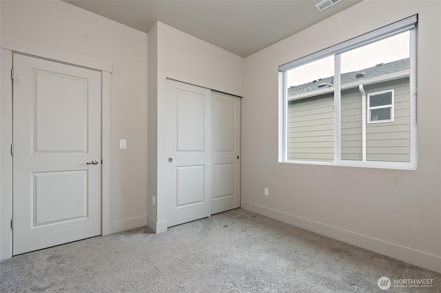 unfurnished bedroom with light carpet, a closet, visible vents, and baseboards