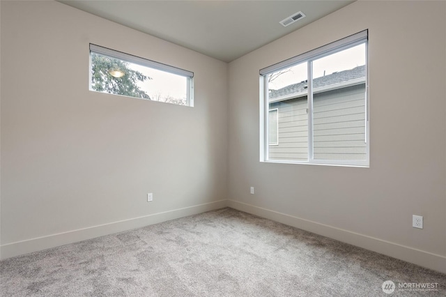 spare room with baseboards, visible vents, and light colored carpet