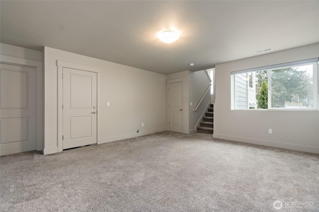 unfurnished room featuring light carpet, visible vents, stairs, and baseboards