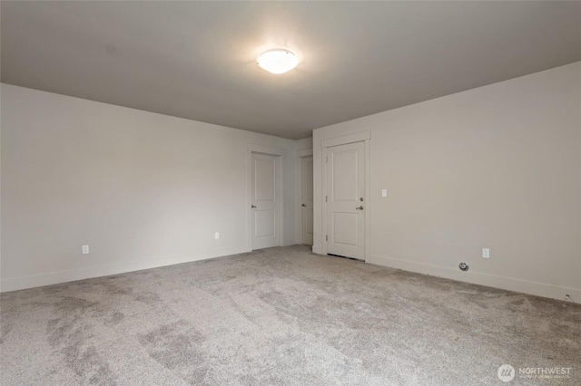 carpeted spare room featuring baseboards