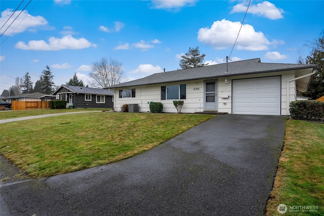 ranch-style home featuring a garage, central air condition unit, and a front lawn