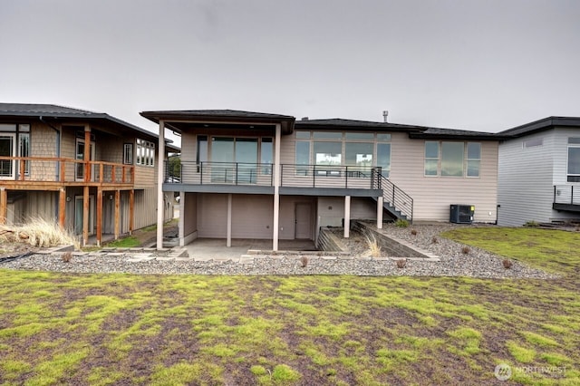 rear view of property with a yard, a patio, a wooden deck, and central AC unit