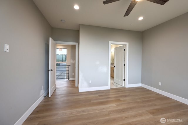 unfurnished bedroom featuring light wood-type flooring, ensuite bath, and ceiling fan