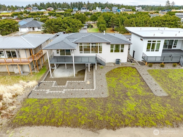 back of property featuring central AC and a carport