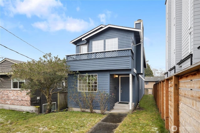 view of front of house featuring a front yard, fence, a chimney, and entry steps