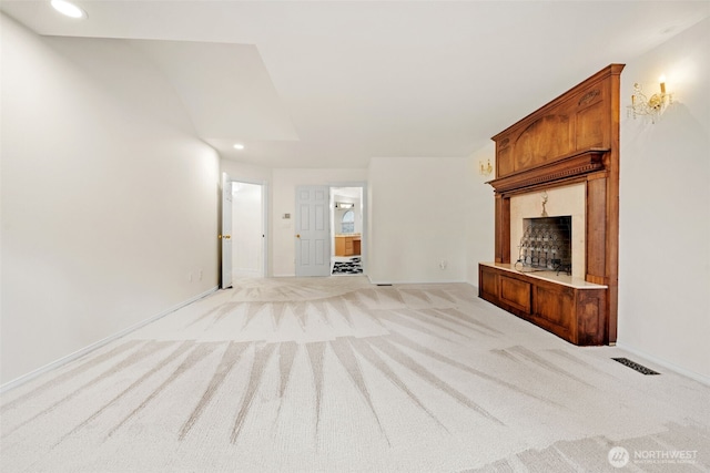 unfurnished living room featuring a fireplace and light colored carpet