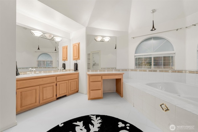 bathroom featuring tiled bath, vanity, and tile patterned flooring