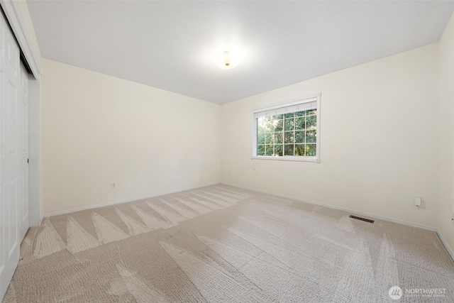 unfurnished room featuring light colored carpet