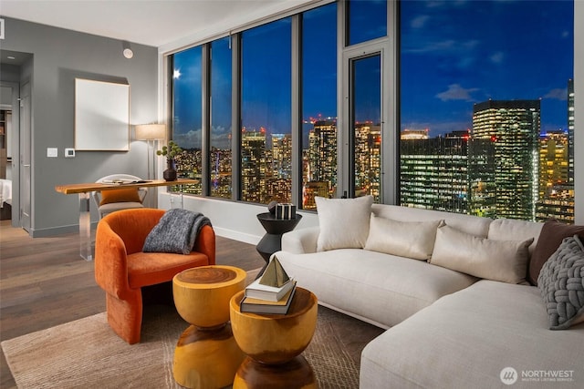 living area with a view of city lights, visible vents, and wood finished floors