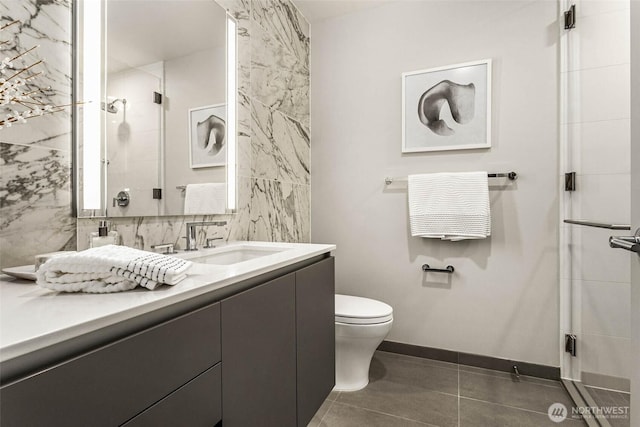 bathroom with toilet, vanity, baseboards, backsplash, and a shower stall