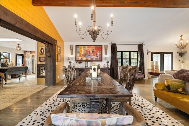 dining space featuring beamed ceiling, wood walls, wood finished floors, and an inviting chandelier