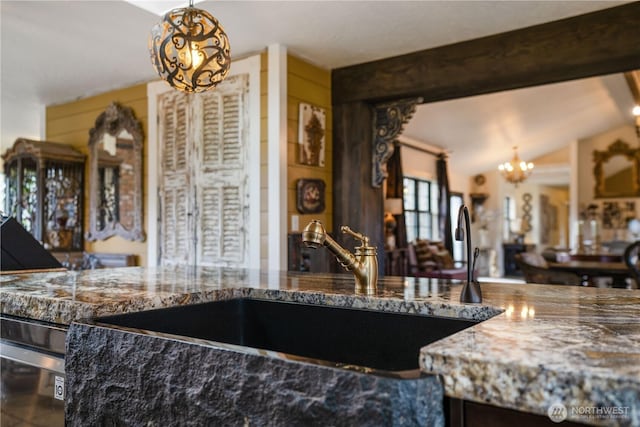 kitchen featuring a sink, lofted ceiling with beams, and an inviting chandelier