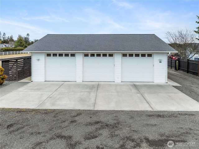 detached garage featuring fence