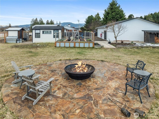 back of property featuring a yard, a fire pit, a patio, and an outdoor structure