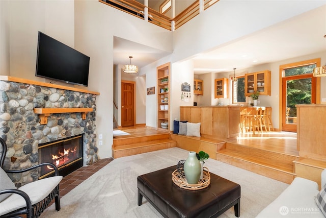 living room featuring built in shelves, a towering ceiling, and a fireplace