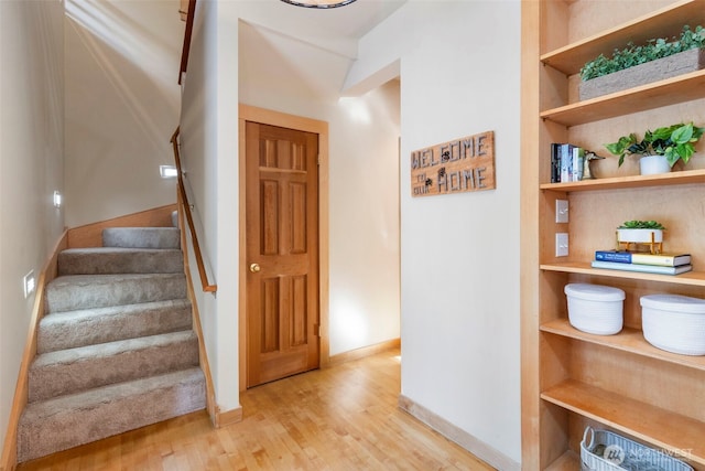 staircase featuring built in features and wood-type flooring