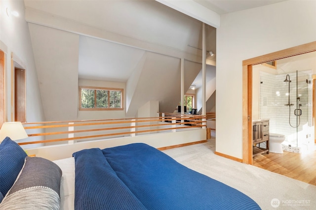 bedroom featuring lofted ceiling, ensuite bathroom, and wood-type flooring