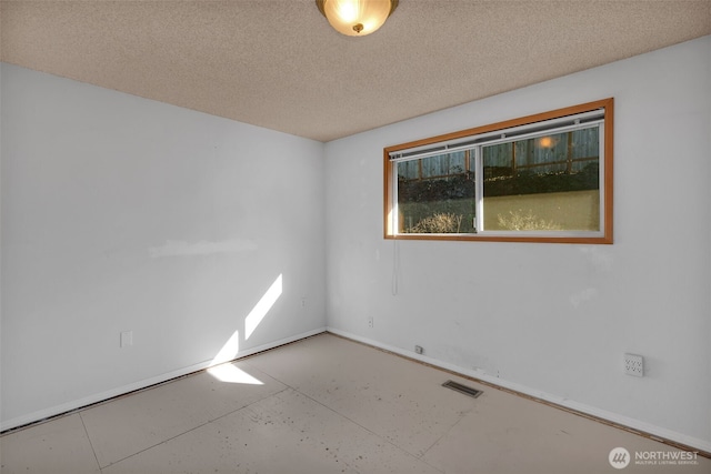 spare room featuring visible vents and a textured ceiling