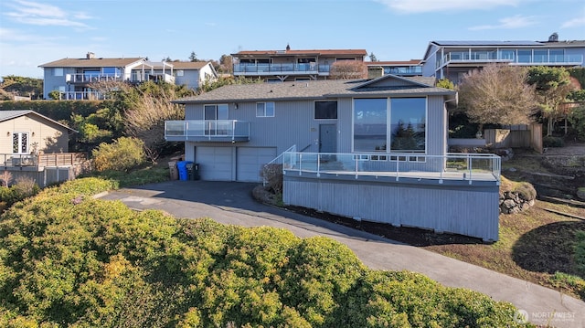 rear view of house featuring driveway and an attached garage