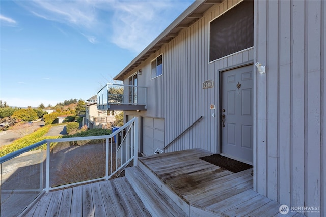 view of exterior entry featuring a balcony and board and batten siding