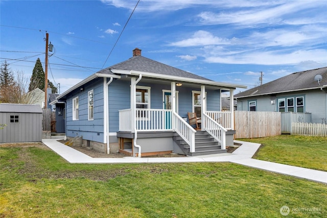 bungalow featuring a storage unit and a front lawn