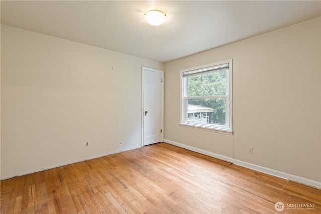 empty room with light wood-type flooring and baseboards