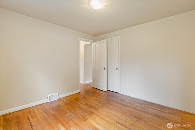 unfurnished room with baseboards, visible vents, and light wood finished floors