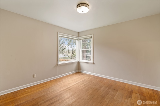 empty room featuring light wood-type flooring and baseboards