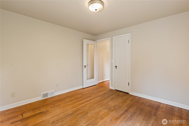 unfurnished room with light wood-style floors, baseboards, and visible vents