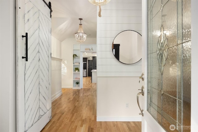 foyer entrance featuring light wood-type flooring and a barn door