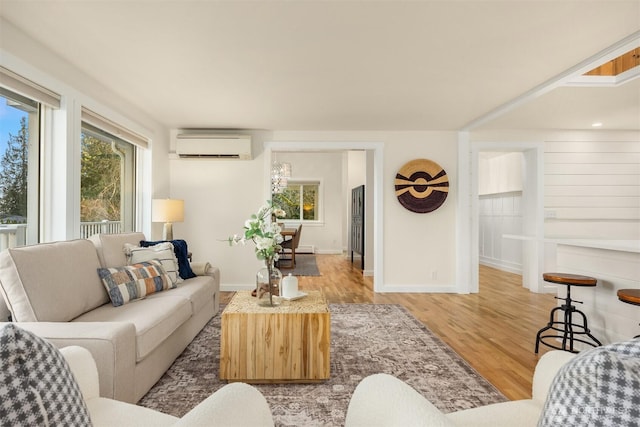 living room featuring an AC wall unit and light hardwood / wood-style flooring